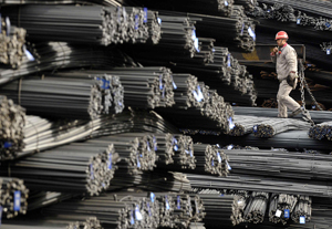 A labourer walks on the steel bars at a steel and iron factory in Changzhi